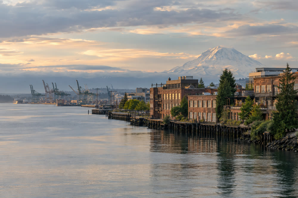 The Tacoma waterfront with brick warehouse lofts, port cranes and Mount Rainier beyond